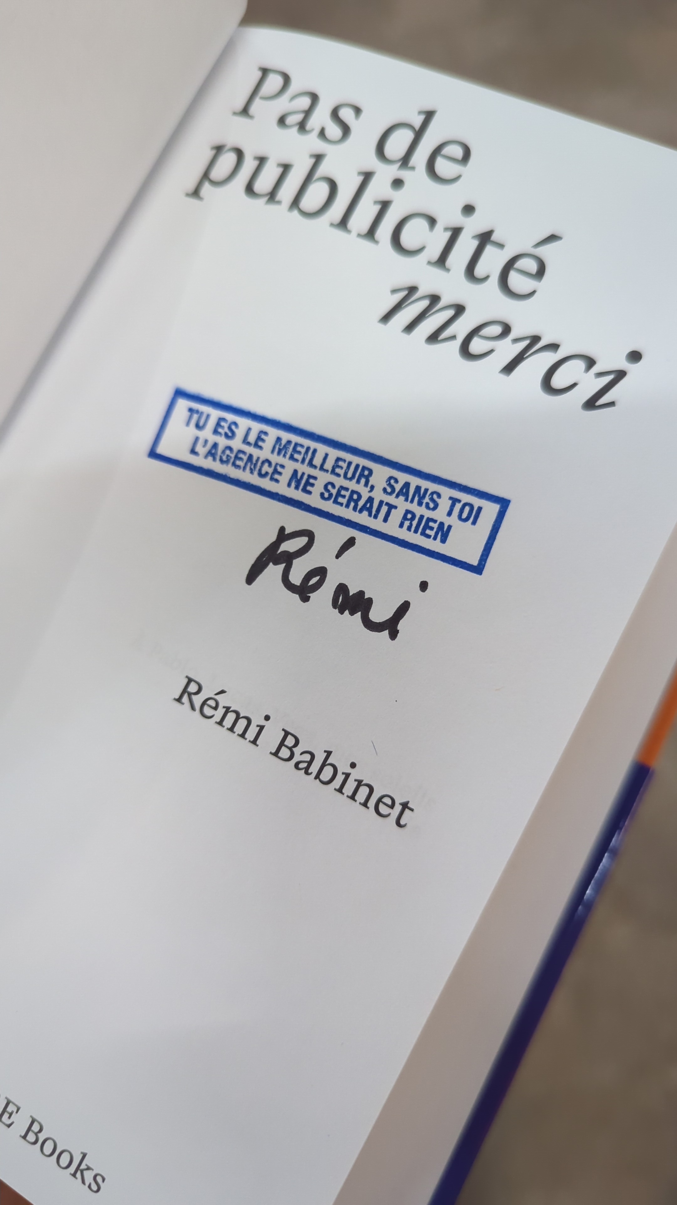 Livre ouvert “Pas de publicité merci” avec dédicace manuscrite signée Rémi Babinet.